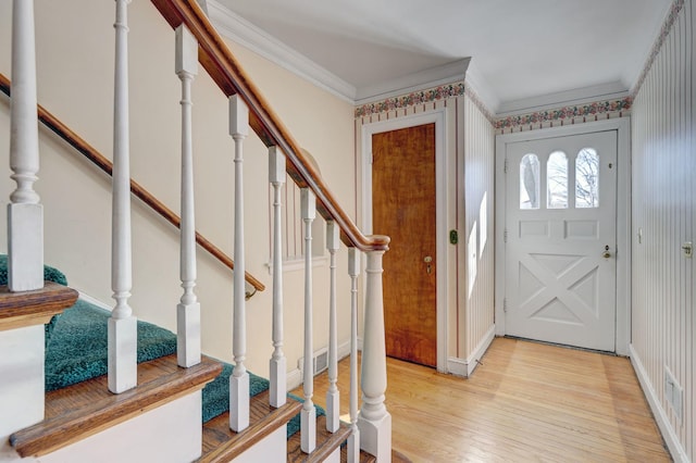 entrance foyer featuring crown molding, light wood-style flooring, baseboards, and stairs