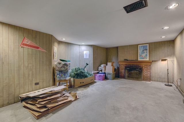 interior space featuring wooden walls, visible vents, concrete floors, a fireplace, and recessed lighting