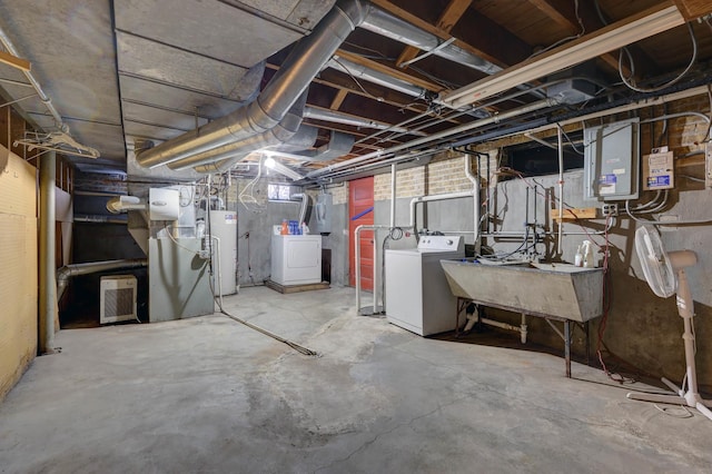 basement featuring water heater, a sink, and washing machine and dryer