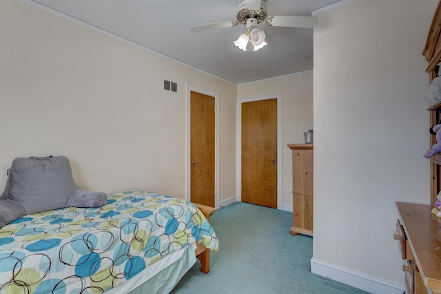 carpeted bedroom with ornamental molding, visible vents, ceiling fan, and baseboards