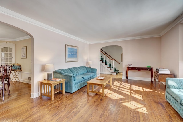 living area featuring stairs, arched walkways, and wood finished floors