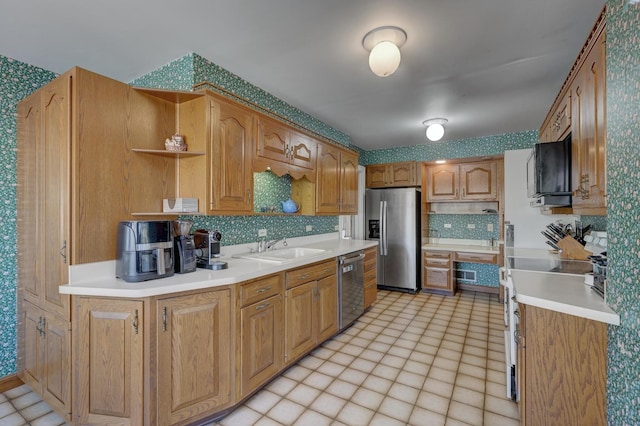 kitchen with stainless steel appliances, a sink, light countertops, decorative backsplash, and open shelves