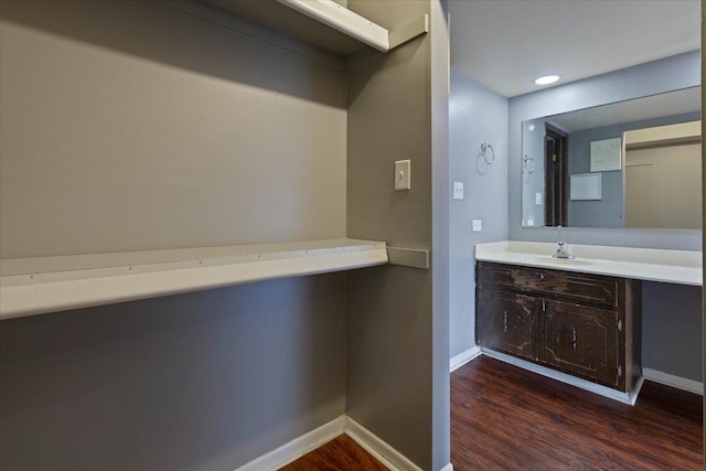 bathroom featuring vanity, baseboards, and wood finished floors