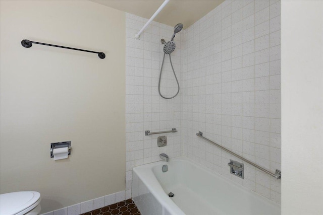 full bathroom featuring tile patterned floors, baseboards, toilet, and tub / shower combination