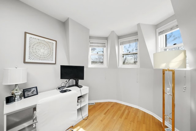 home office with light wood-type flooring and baseboards