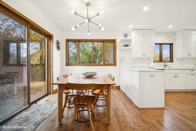 dining room featuring light wood-type flooring, an inviting chandelier, baseboards, and recessed lighting