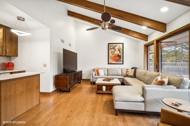 living room with lofted ceiling with beams, light wood-type flooring, visible vents, and baseboards