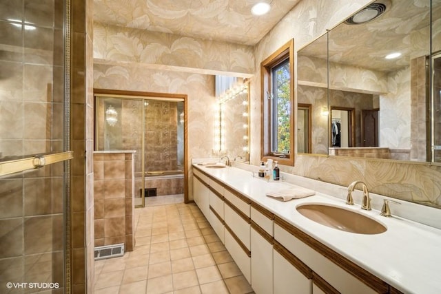 full bath with tile patterned flooring, a sink, visible vents, double vanity, and wallpapered walls