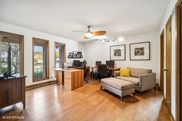 home office featuring light wood finished floors, baseboards, a ceiling fan, and rail lighting