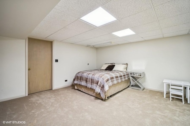 bedroom with carpet flooring, a drop ceiling, and baseboards