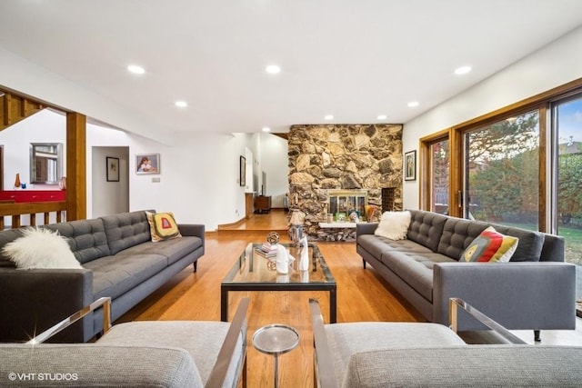 living room featuring recessed lighting, a fireplace, and wood finished floors