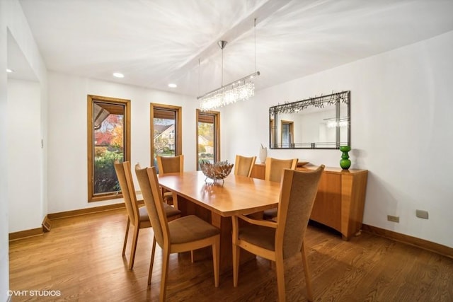 dining space with baseboards, wood finished floors, and recessed lighting