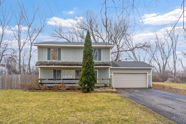 traditional home with an attached garage, fence, aphalt driveway, and a front yard