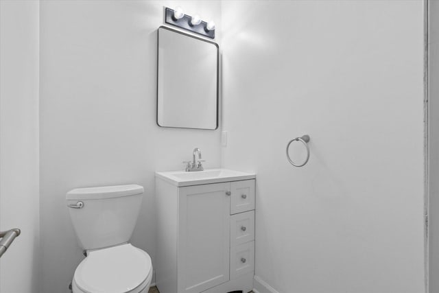 half bathroom with vanity and toilet