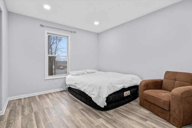 bedroom with light wood-type flooring, baseboards, and recessed lighting