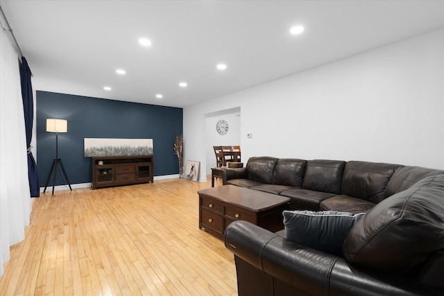 living room with recessed lighting, baseboards, and light wood finished floors