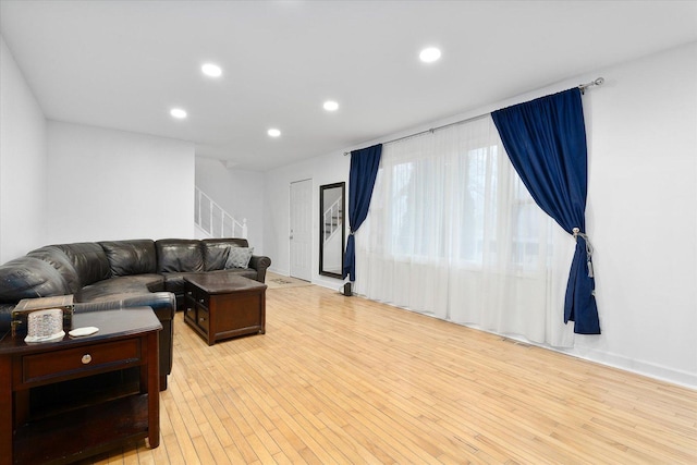 living room with light wood-style flooring, stairway, and recessed lighting