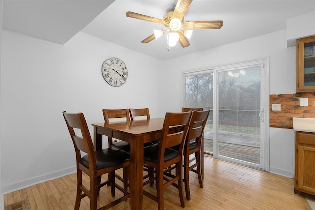 dining area with light wood-style floors, ceiling fan, and baseboards