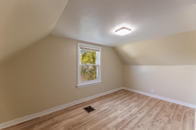 bonus room featuring visible vents, vaulted ceiling, light wood finished floors, and baseboards