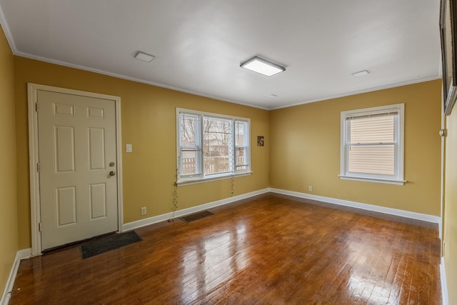 spare room featuring baseboards, visible vents, crown molding, and hardwood / wood-style floors