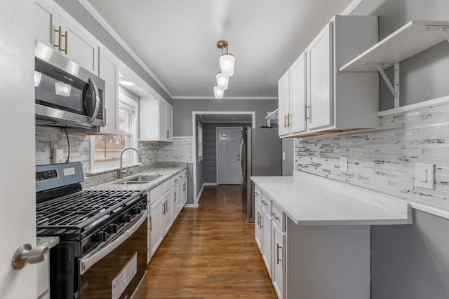 kitchen featuring a sink, white cabinetry, appliances with stainless steel finishes, light stone countertops, and crown molding