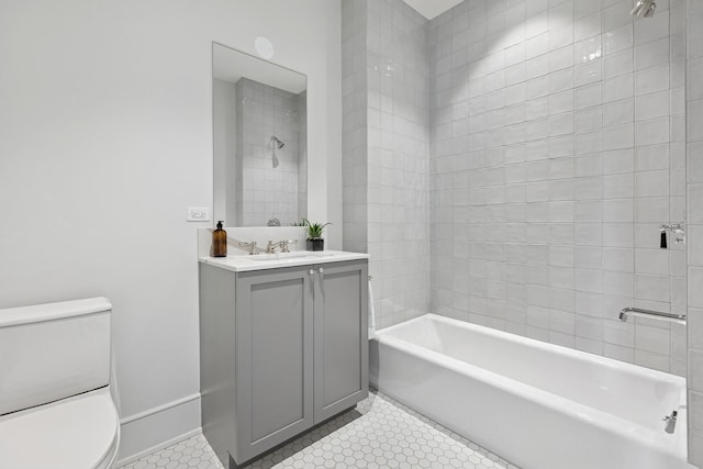 bathroom with toilet, vanity, baseboards,  shower combination, and tile patterned floors