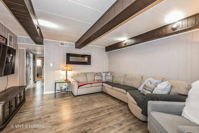 living room with visible vents, beam ceiling, and wood finished floors