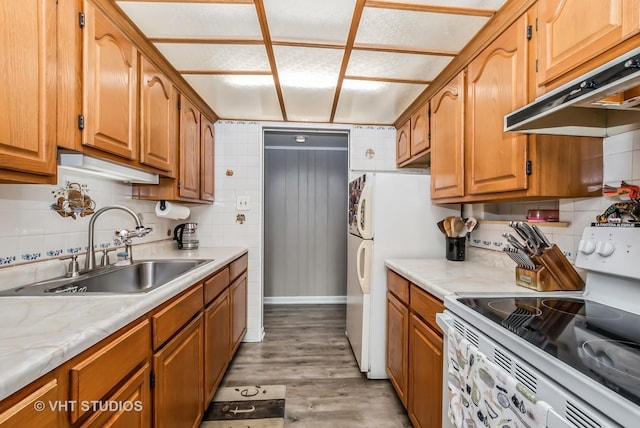 kitchen featuring light countertops, white electric range, a sink, light wood-type flooring, and under cabinet range hood