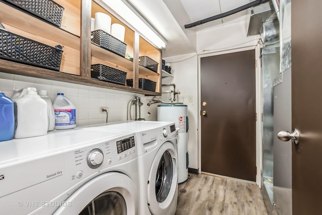 washroom with light wood-type flooring, laundry area, water heater, and independent washer and dryer