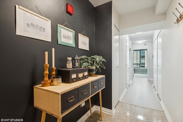 hall with granite finish floor and baseboards