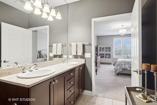 bathroom featuring a chandelier, a sink, and ensuite bathroom