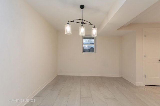 unfurnished room with baseboards