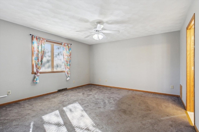 unfurnished room with carpet floors, baseboards, visible vents, and a ceiling fan