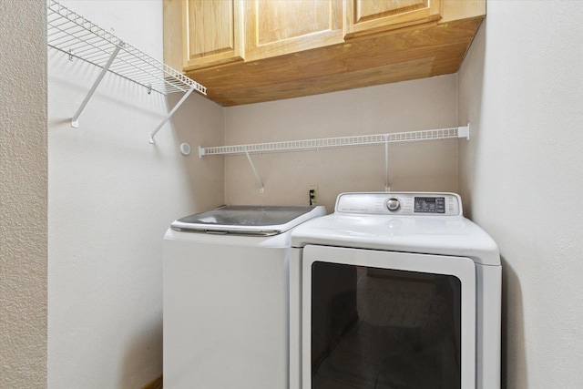 washroom with cabinet space and washer and clothes dryer