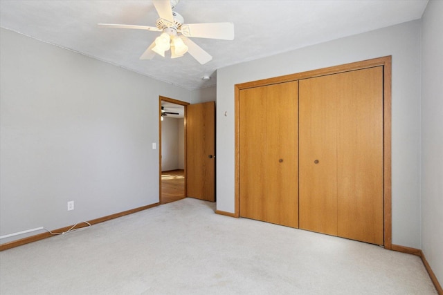 unfurnished bedroom with light carpet, a ceiling fan, baseboards, and a closet