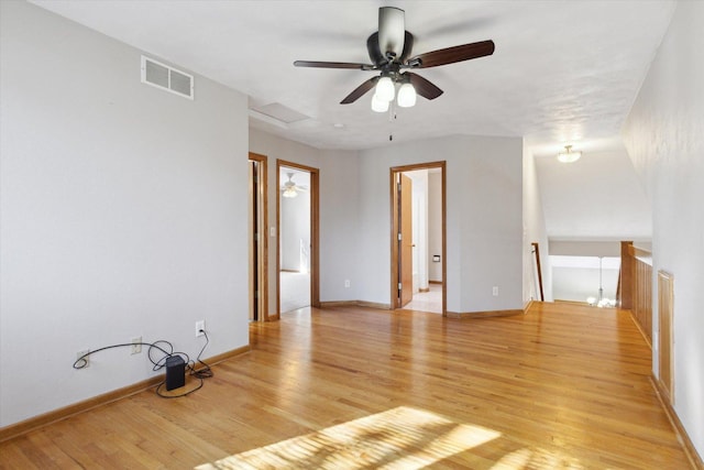 empty room featuring light wood-type flooring, visible vents, and baseboards