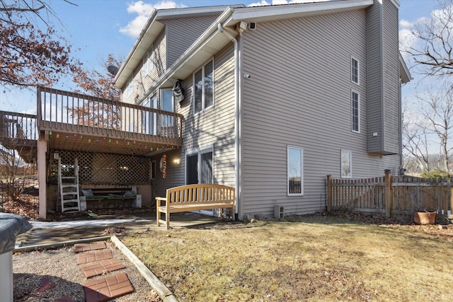 exterior space with stairs, fence, a deck, and a lawn