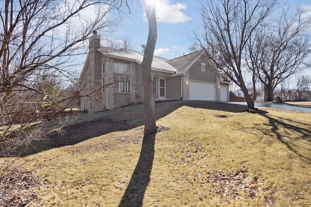 view of front of house with a garage, a front yard, and a chimney