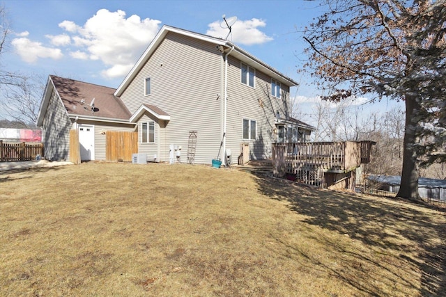 back of house with a deck, a lawn, and fence