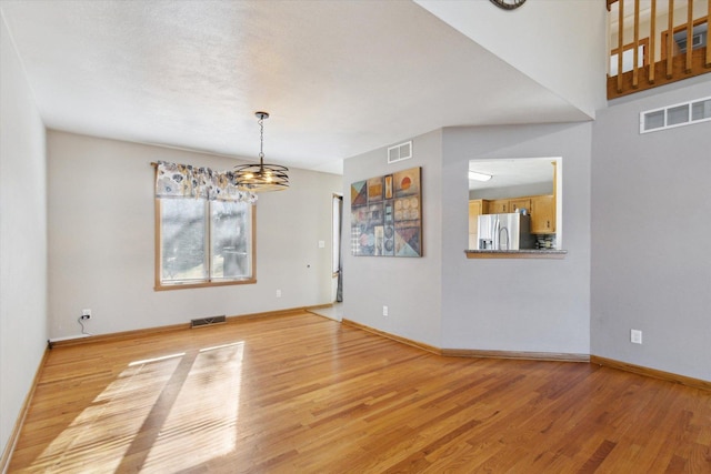 unfurnished dining area featuring light wood-style floors, visible vents, and baseboards