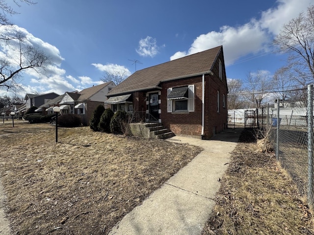 bungalow-style house featuring brick siding and fence