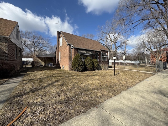 view of property exterior with brick siding and roof with shingles