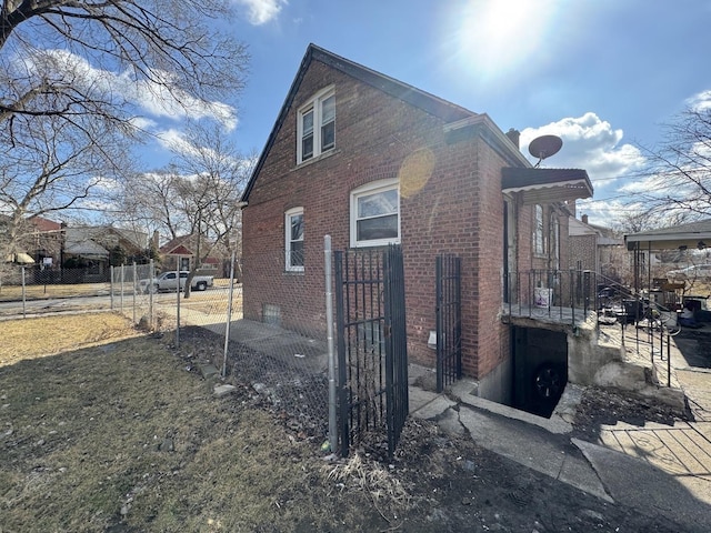 view of side of home featuring brick siding and fence