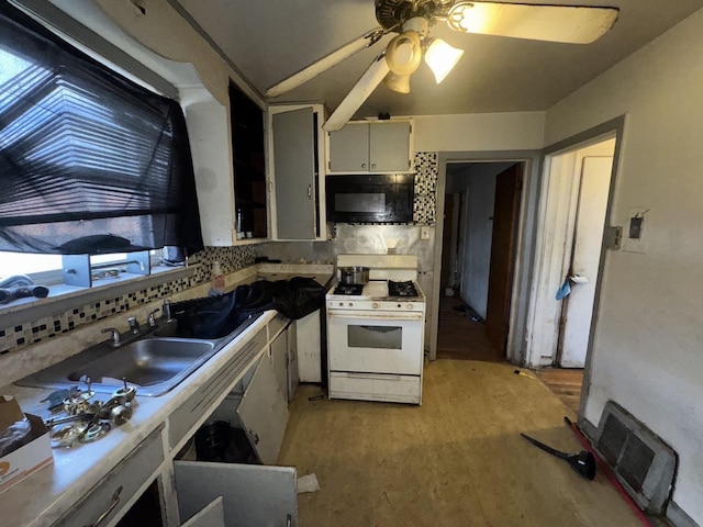 kitchen with white gas stove, tasteful backsplash, visible vents, a sink, and black microwave