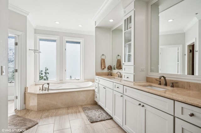 full bath with crown molding, a garden tub, a sink, and double vanity