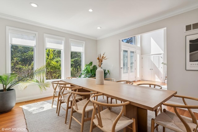 dining area with light wood finished floors, baseboards, visible vents, crown molding, and recessed lighting