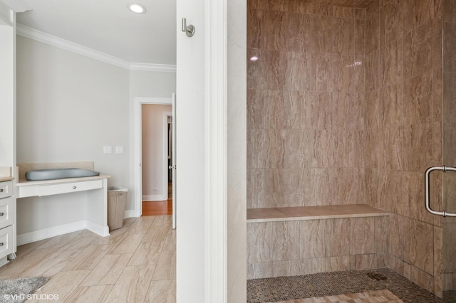 bathroom with a stall shower, baseboards, and crown molding