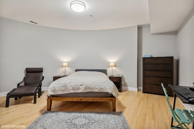 bedroom featuring light wood-type flooring, visible vents, and baseboards