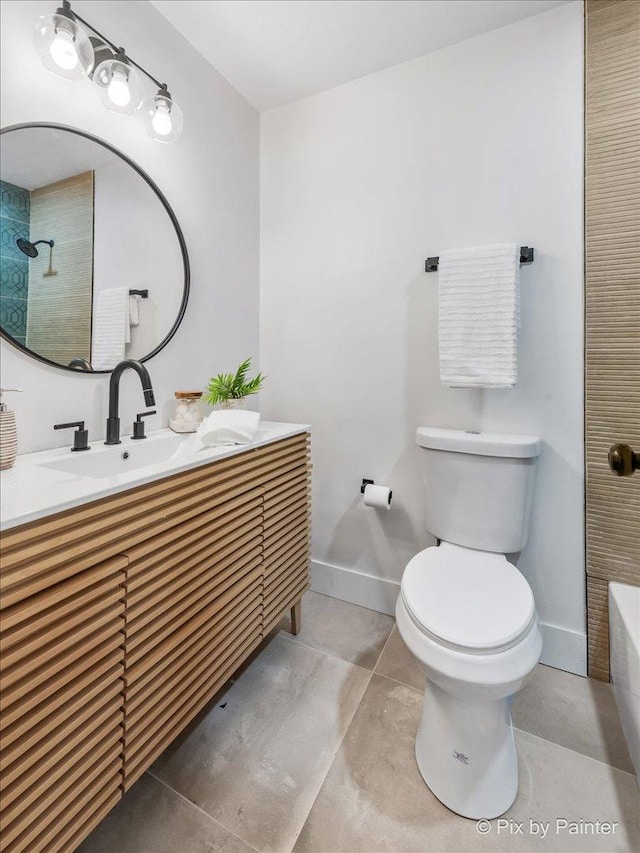 bathroom featuring vanity, tile patterned flooring, toilet, and baseboards