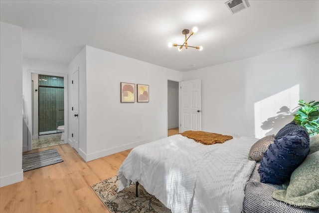 bedroom featuring light wood-type flooring, visible vents, a notable chandelier, and baseboards